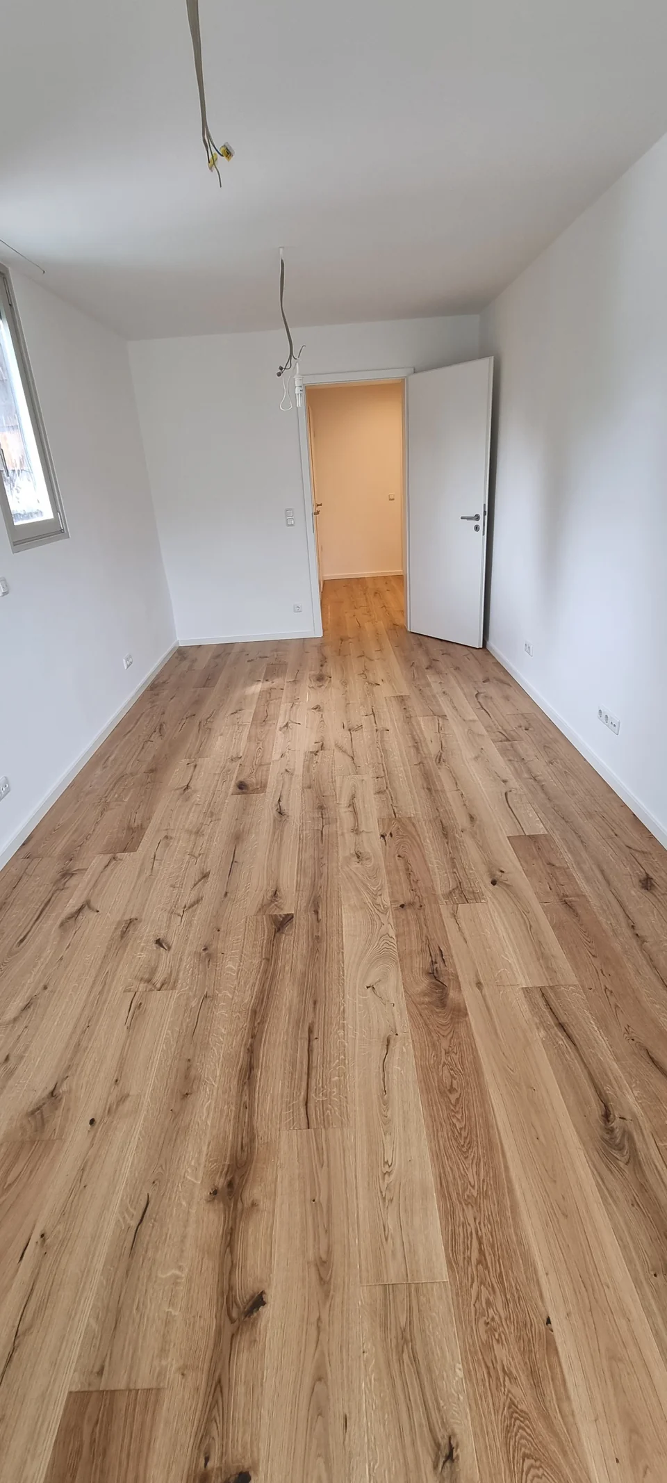 Parkettboden mit weißen Sockelleisten und sauberem Abschluss